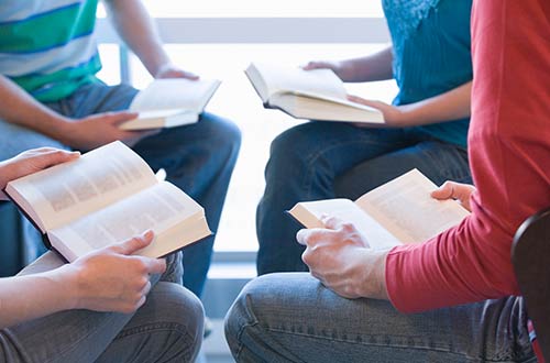 Group sitting together with open books